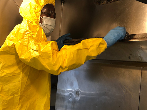 Service Technician cleaning a kitchen exhaust system