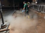A CKC technician pressure washes a sidewalk