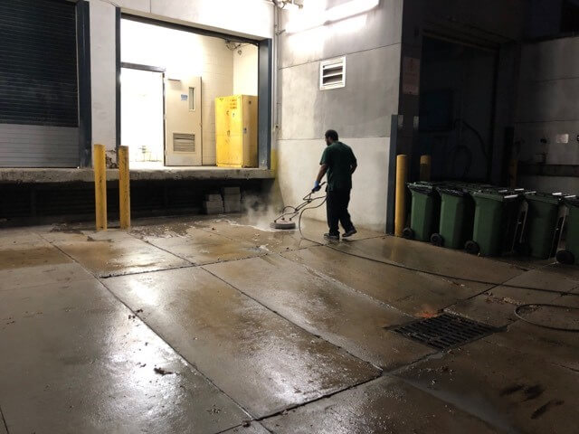 A CKC technician cleans a loading dock